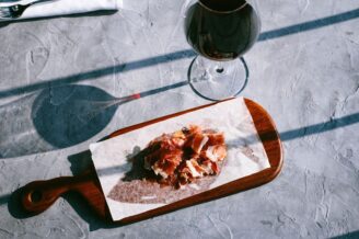 Verre de vin rouge et jambon cru sur une planche en bois