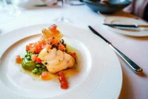 Assiette bistronomique de poisson, légumes verts et dés de tomate