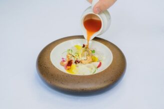 Sauce versée sur un plat raffiné dans un bol en céramique artisanale